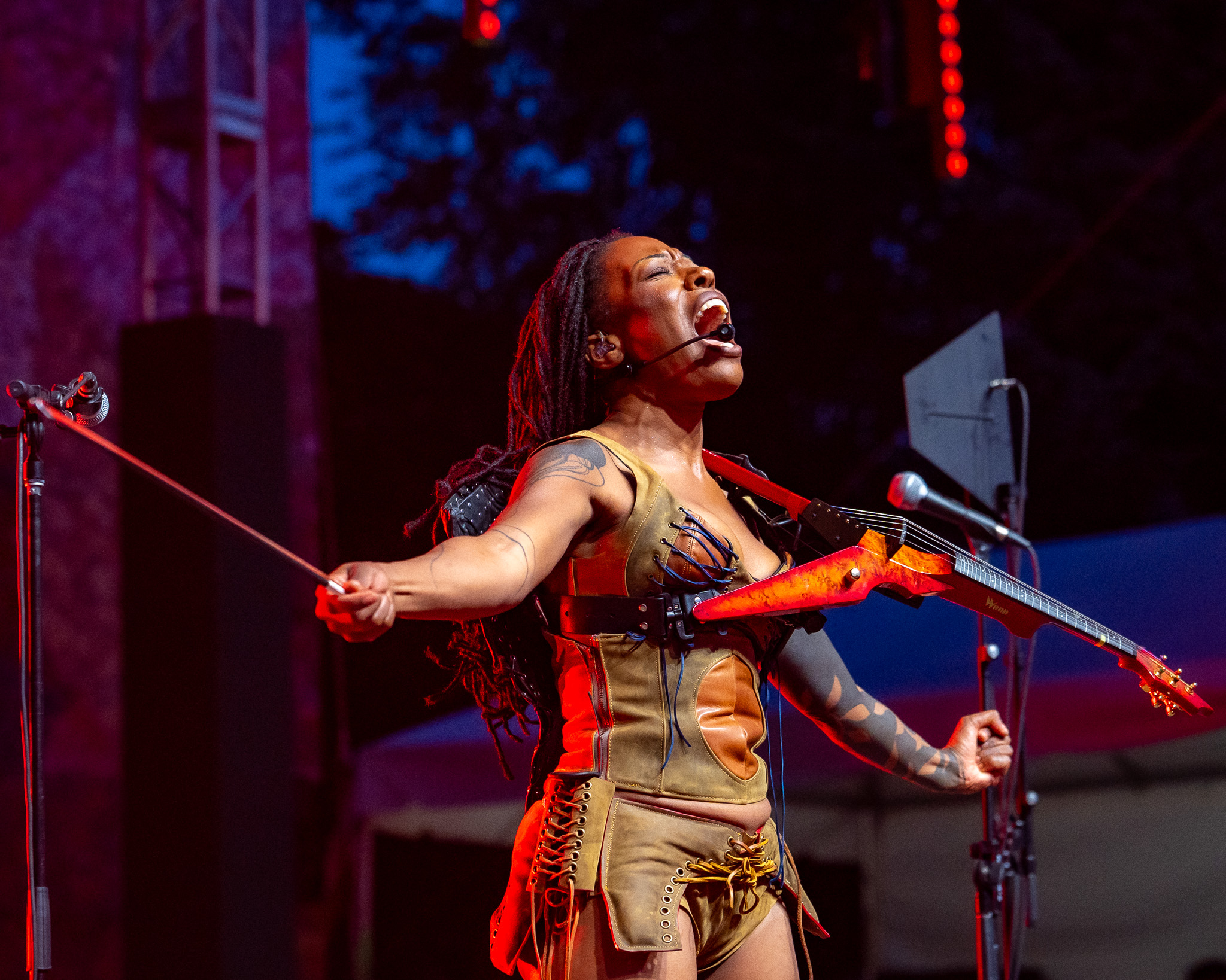 Sudan Archives playing violin beneath saturated light